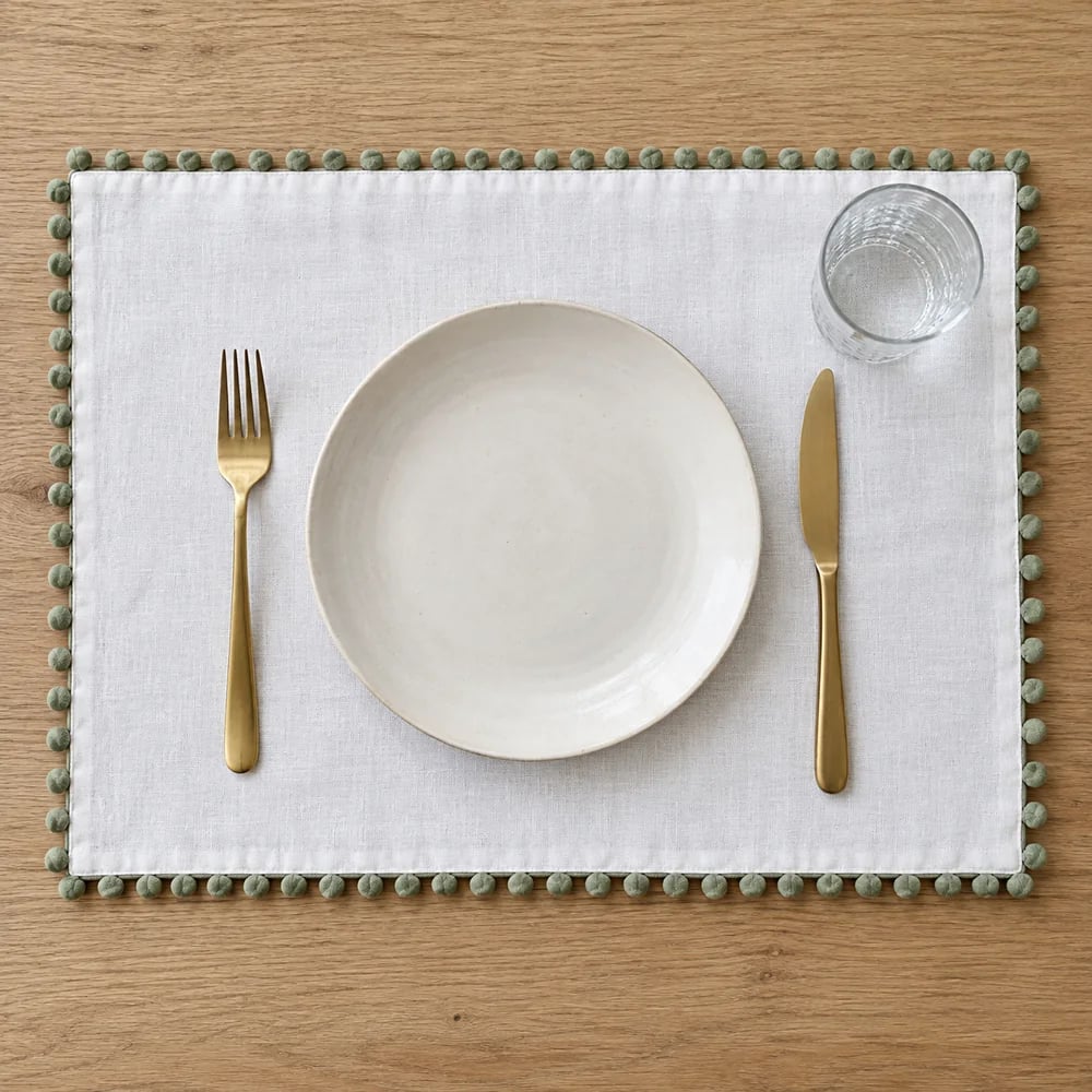 White placemat, pom pom trim